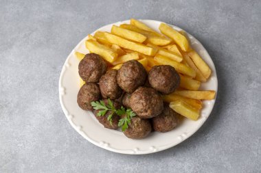 Yuvarlak şekilli köfteler ve patates kızartması. Türkçe adı: kuru kofte ve patates