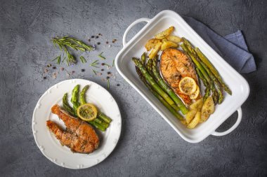 Izgara, fırında somon, kuşkonmaz ve patatesle servis edilir..