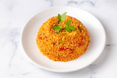 Tabakta domates sosu bulunan geleneksel Türk bulgur pilavı (Türkçe adı; meyhane pilavi))