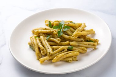 Gri arka planda kişniş soslu Casarecce makarna, üst manzara. Lezzetli vejetaryen yemeği.