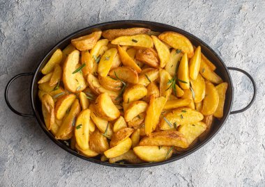 Kızarmış patates kamışı, otlar ve tabakta deniz tuzu, üst görünüm (Türk adı; elma dilim patatesi))