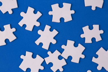Missing jigsaw puzzle pieces. Business concept. Fragment of a folded white jigsaw puzzle and a pile of uncombed puzzle elements against