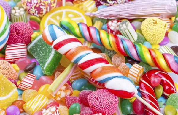 Красочные леденцы и разноцветные круглые конфеты. Вид сверху.