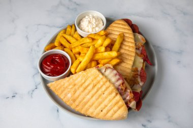 Türk tostu, çedar peyniri, sosis ve jambonla karıştırılmış tost, kızarmış patates (Türk adı Karisik tost))