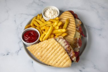 Türk tostu, çedar peyniri, sosis ve jambonla karıştırılmış tost, kızarmış patates (Türk adı Karisik tost))
