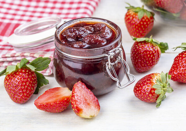 Домашний вкусный клубничный джем и клубника на деревенском деревянном столе