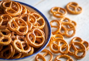 Ahşap arka planda tuzlu mini krakerler. Seçici odak.