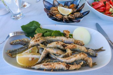 Kızarmış balık, midye ve birayla nefis bir sofra.