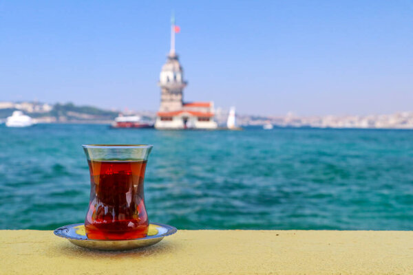 Magnific view of Maiden's Tower (Kiz kulesi) and traditional turkish tea on the front. Istanbul attractions.