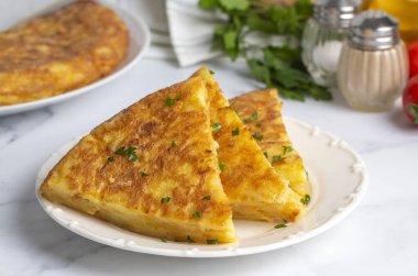Spanish omelette with potatoes, typical spanish cuisine on gray concrete floor. Tortilla Espanola. Turkish name; Yumurtali patates