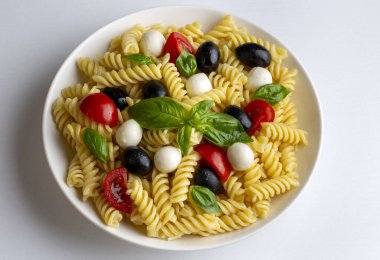 İtalyan soğuk makarna salatası ya da makarna fredda alla caprese. Tam üstte. Fusilli, domates, mozzarella, zeytin, roka. Türk ismi; burgu makarna salatasi