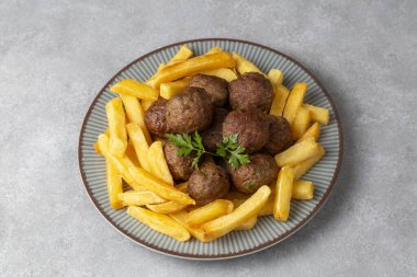 Yuvarlak şekilli köfteler ve patates kızartması. Türkçe adı: kuru kofte ve patates