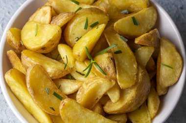 Kızarmış patates kamışı, otlar ve tabakta deniz tuzu, üst görünüm (Türk adı; elma dilim patatesi))