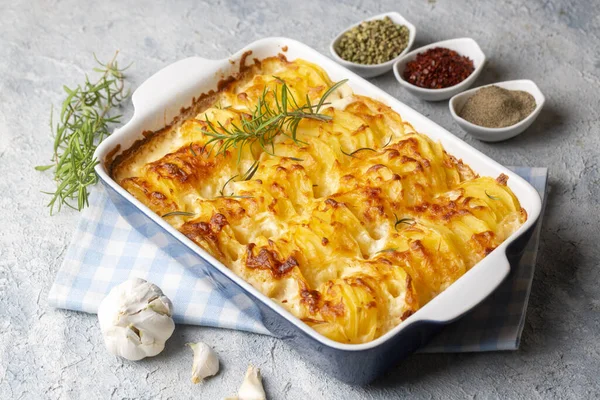 stock image Potato gratin - graten (baked potatoes with cream and cheese) with rosemary and forks (Turkish name; Kremali patates)