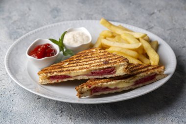 Türk tostu, çedar peyniri, sosis ve jambonla karıştırılmış tost, kızarmış patates (Türk adı Karisik tost))