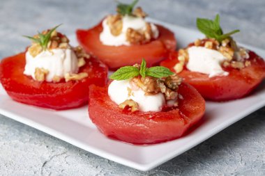 Geleneksel Türk usulü ayva tatlısı. Ayva, üzerine yumuşak şerbet dökülüp krema ve cevizle servis edilene kadar pişirilir. Türkiye 'nin en popüler tatlılarından biridir. (Ayva Tatlisi)