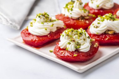 Geleneksel Türk usulü ayva tatlısı. Ayva, üzerine yumuşak şerbet dökülüp krema ve cevizle servis edilene kadar pişirilir. Türkiye 'nin en popüler tatlılarından biridir. (Ayva Tatlisi)