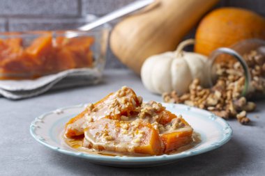 Tahinili balkabağı tatlısı ve beyaz porselen tabakta ceviz.