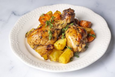 Baked chicken thighs and fried potatoes look delicious.