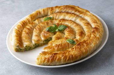 Traditional Turkish pastry with spinach. (Turkish Name: Ispanakli Kol Boregi, Bosnak boregi). Handmade pastry with spinach filling.