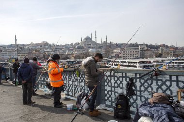 İstanbul - Türkiye, 18 Şubat 2021, Galata Köprüsü 'nde Balıkçı ve Halk, yağmurlu kış günü