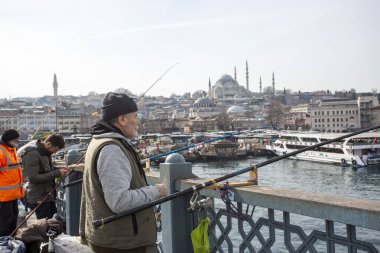 İstanbul - Türkiye, 18 Şubat 2021, Galata Köprüsü 'nde Balıkçı ve Halk, yağmurlu kış günü