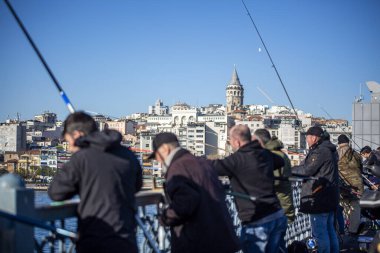 İstanbul / Türkiye, 17 Şubat 2020, Galata Köprüsü 'ndeki ve arkadaki Galata Kulesi' ndeki insanlar