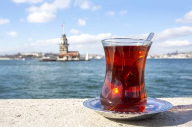 Magnific view of Maiden's Tower (aka Kiz kulesi) and traditional turkish tea on the front. Istanbul attractions.