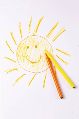 Renkli kalemlerle neşe dolu güneş figürleri.