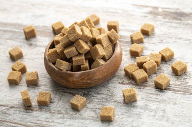 Tahta arka planda kahverengi şeker küpleri