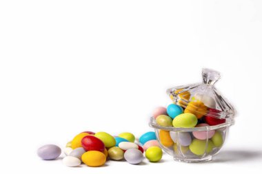 Colorful almond candies in the stylish,crystal candy bowl on white with copy space.The Sugar Feast concept. (Turkish name; Ramadan - Ramazan bayrami, Seker bayrami)