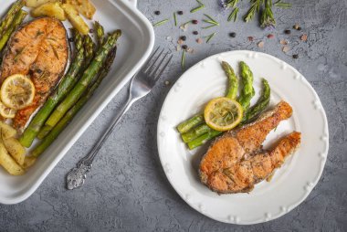 Izgara, fırında somon, kuşkonmaz ve patatesle servis edilir..