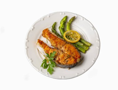 Izgara, fırında somon, kuşkonmaz ve patatesle servis edilir.