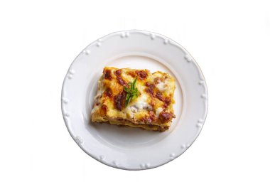 Portion of ground beef lasagna topped with melted cheese and garnished with fresh parsley served on a plate in close view for a menu