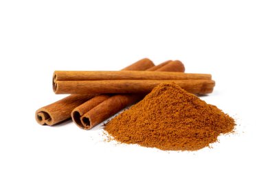 Tarçın çubukları ve beyaz arkaplanda izole edilmiş toz yığını