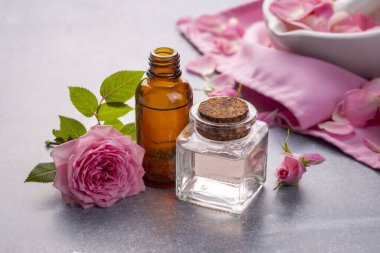 Bir şişe gül yağı ve çiçek.