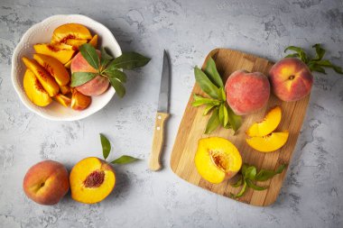 Tahta fonda ahşap kasede taze sarı şeftali meyvesi ahşap sepette dilimlenmiş sarı şeftali..