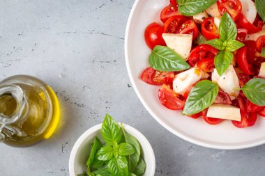 Dilimlenmiş domates, mozzarella, fesleğen, zeytin yağı ile İtalyan Caprese salatası