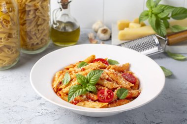 Klasik İtalyan usulü makarna penne alla arrabiata fesleğen ve taze rendelenmiş parmesan peyniri. Acı soslu arrabbiata soslu makarna..