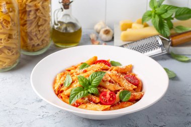 Classic italian pasta penne alla arrabiata with basil and freshly grated parmesan cheese on dark table. Penne pasta with chili sauce arrabbiata. clipart