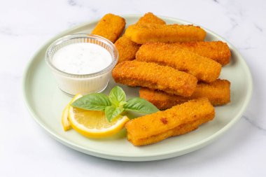 Balık ve patates kızartması. Ekmek kırıntıları ve limon sosuyla servis edilen kızarmış balık kroketlerine yakın olsun.