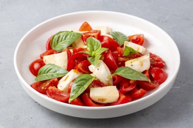 Dilimlenmiş domates, mozzarella, fesleğen, zeytin yağı ile İtalyan Caprese salatası