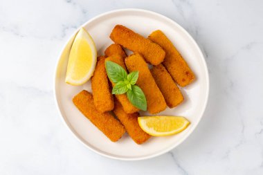 Balık ve patates kızartması. Ekmek kırıntıları ve limon sosuyla servis edilen kızarmış balık kroketlerine yakın olsun.
