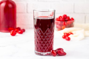 Hafif arkaplanda bir bardak dogwood meyveli içecek. Türkçe adı: Kizilcik serbeti