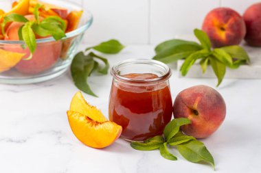 Kavanozda ev yapımı şeftali reçeli ve taze şeftali.