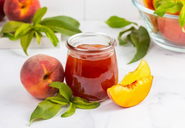 Kavanozda ev yapımı şeftali reçeli ve taze şeftali.