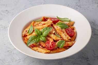 Klasik İtalyan usulü makarna penne alla arrabiata fesleğen ve taze rendelenmiş parmesan peyniri. Acı soslu arrabbiata soslu makarna..