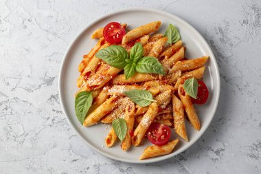 Klasik İtalyan usulü makarna penne alla arrabiata fesleğen ve taze rendelenmiş parmesan peyniri. Acı soslu arrabbiata soslu makarna..