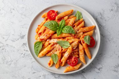 Klasik İtalyan usulü makarna penne alla arrabiata fesleğen ve taze rendelenmiş parmesan peyniri. Acı soslu arrabbiata soslu makarna..