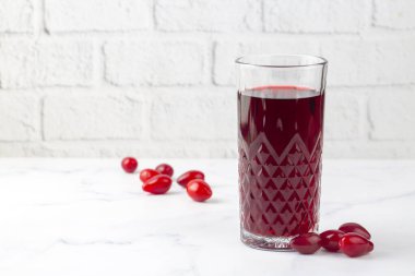 Hafif arkaplanda bir bardak dogwood meyveli içecek. Türkçe adı: Kizilcik serbeti